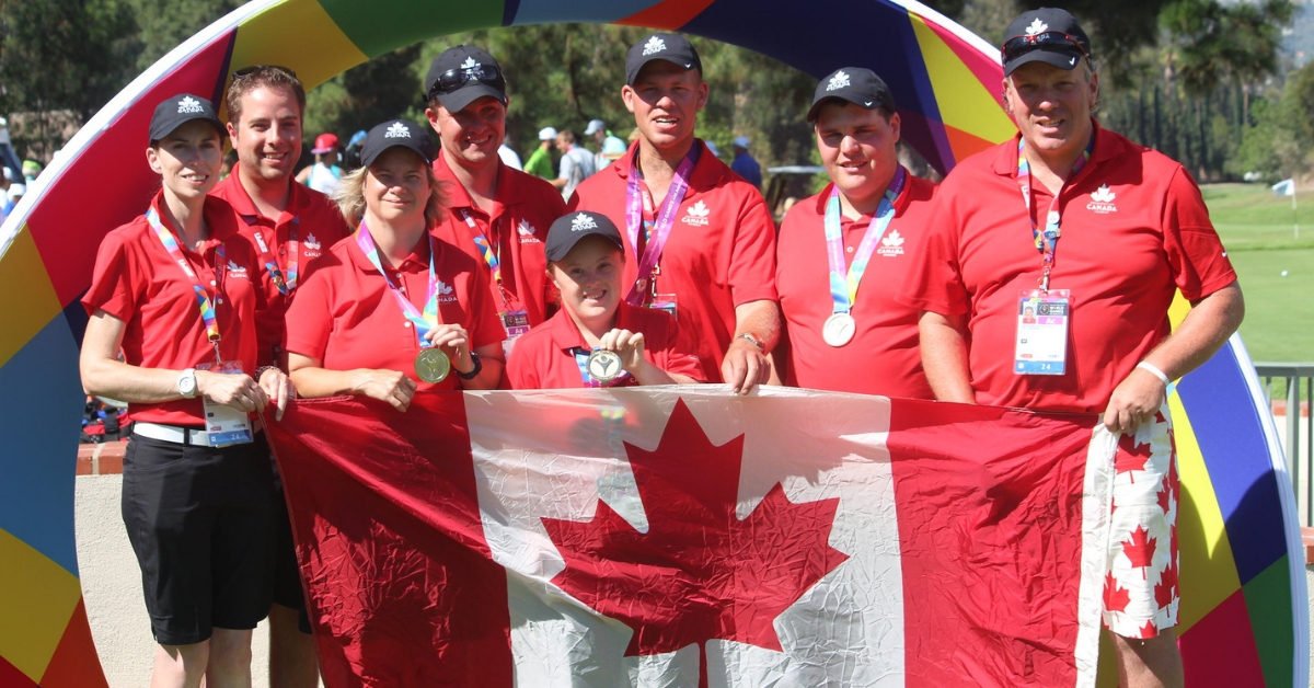 Mike McCarther (back left) holds up a Canadian flag with Special Olympics Team Canada 2015 golfers.