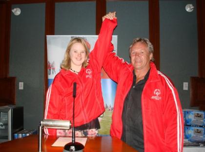 Darryl Sittler poses for a photo with a Special Olympics athlete while holding her arm up.