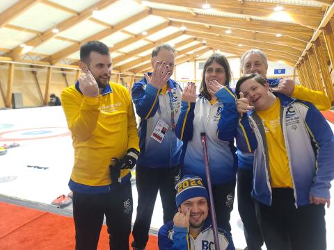 Group photo of curling athletes showing their blue nails
