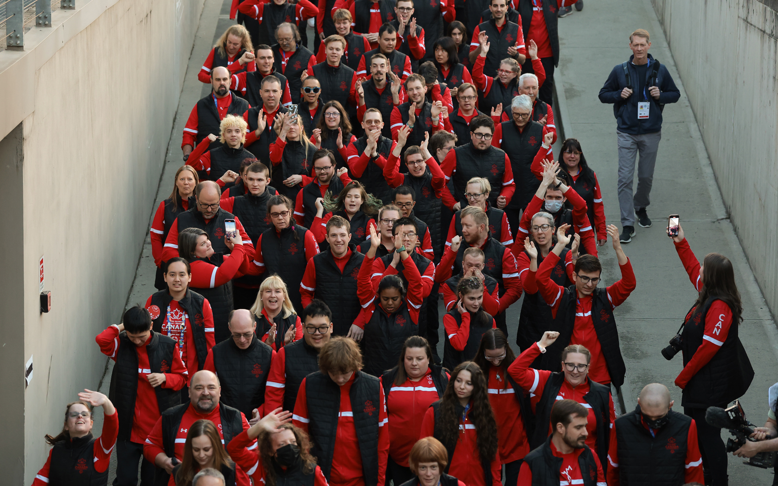 Large group of people walking. All dressed in red Canada gear.