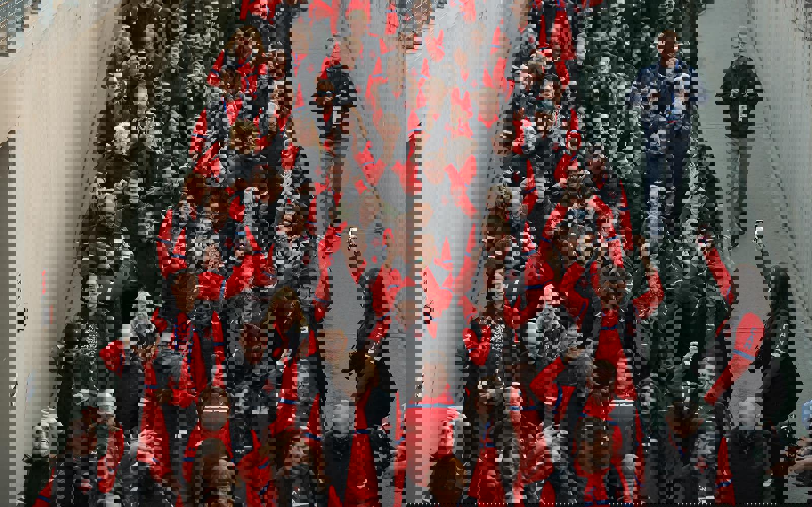 Un grand groupe de personnes marchant. Tous vêtus de vêtements rouges du Canada.