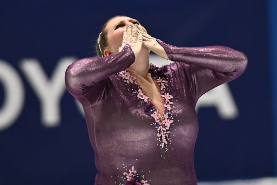 Femme en violet faisant du patinage artistique et envoyant un baiser