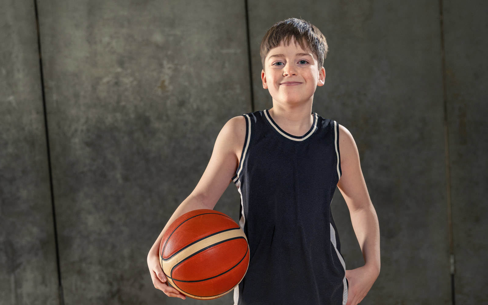 Young Boy in all black holding a basketball 