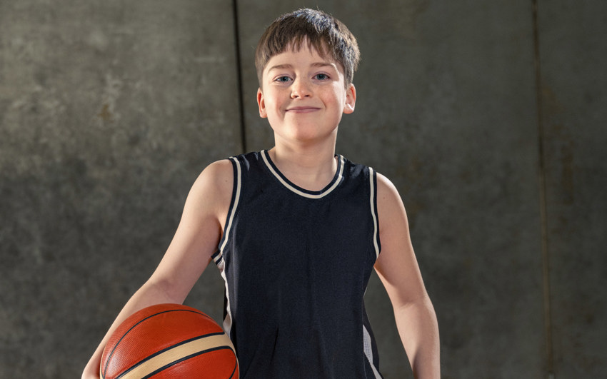 Young Boy in all black holding a basketball