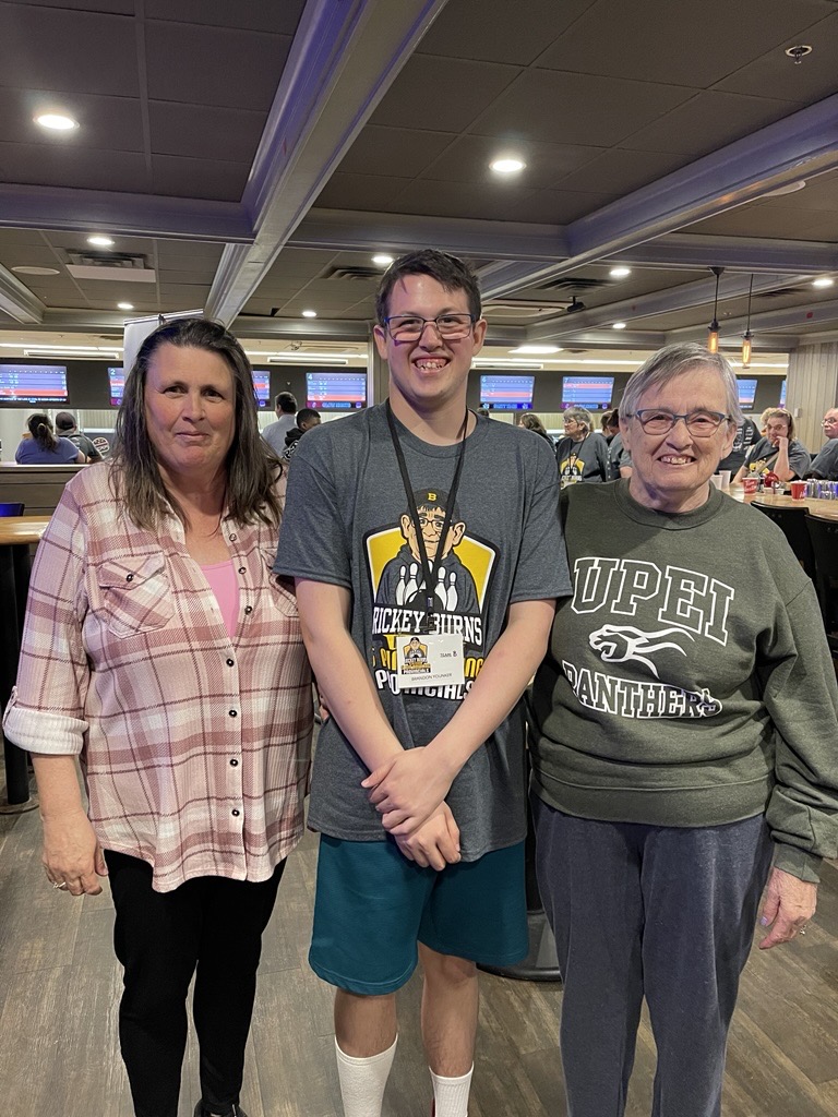 3 people standing at the bowling lanes
