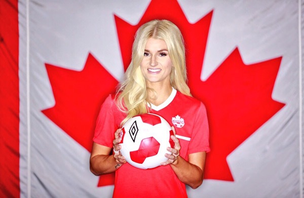 Headshot of a woman with long blond hair in front of a Canadian flag holding a soccer ball. Headshot of a woman with long blond hair in front of a Canadian flag holding a soccer ball.