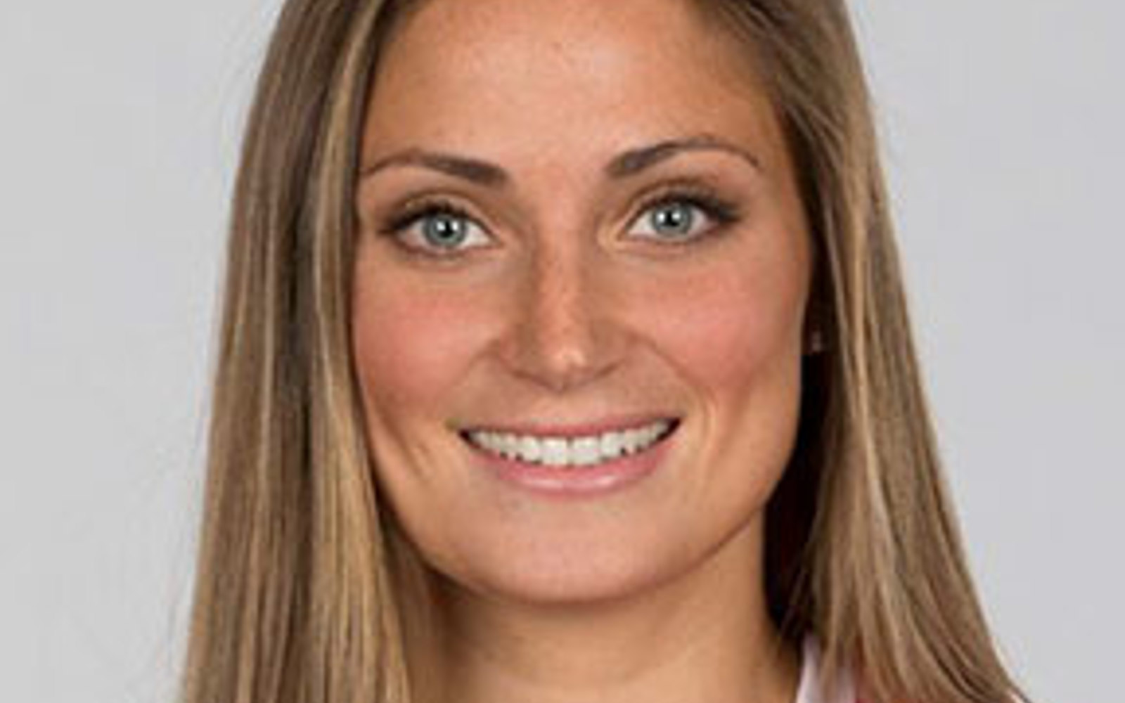 Headshot of a woman with long blond hair wearing a red soccer Canada jersey. 