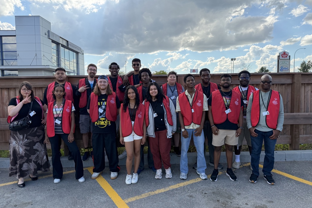 Un groupe de 16 solliciteurs en personne pose ensemble, souriant à la caméra. Ils portent tous des gilets rouges arborant le logo de Special Olympics Canada. 