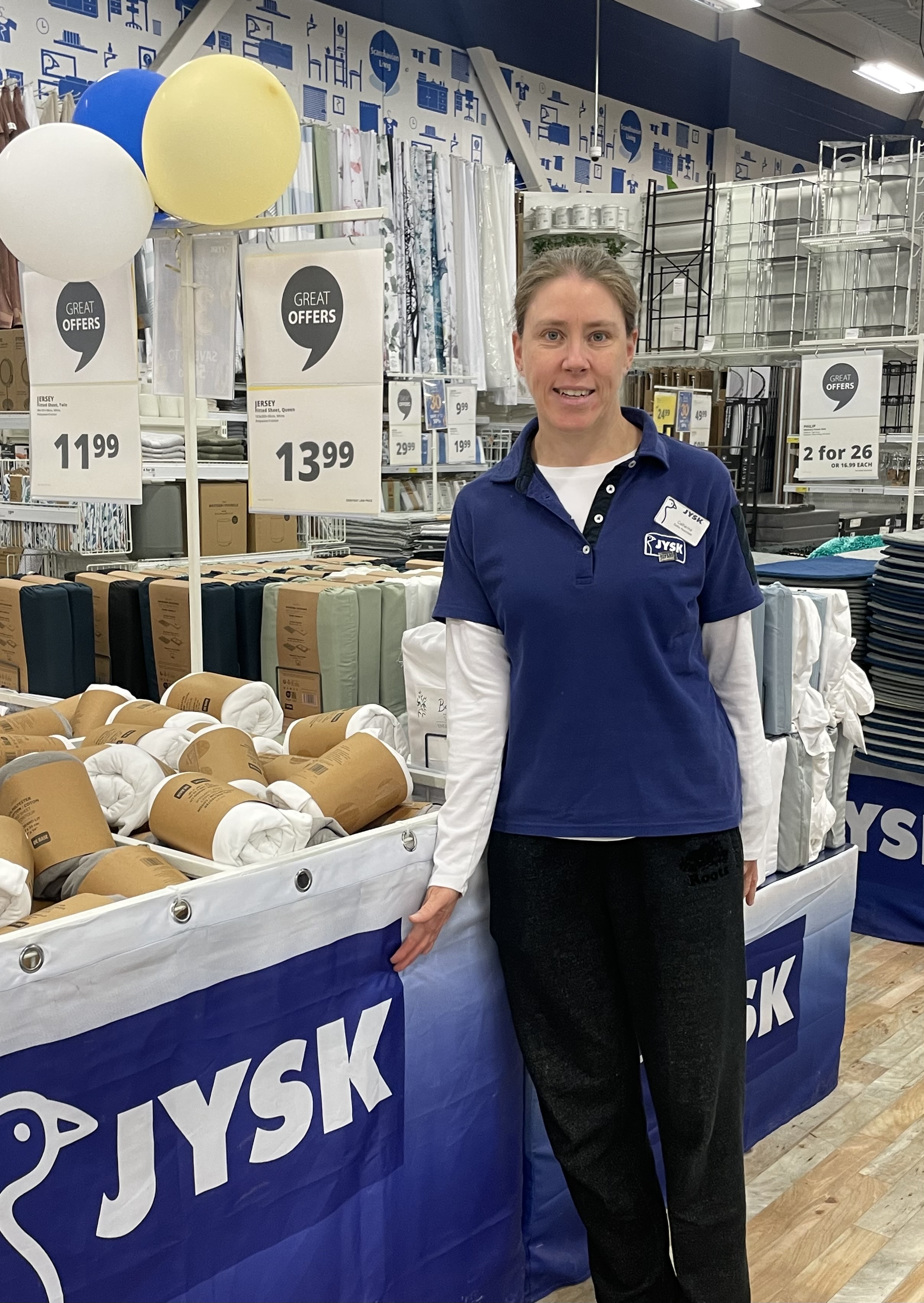 Catherine Partlow at her place of employment, JYSK, wearing her employee uniform.