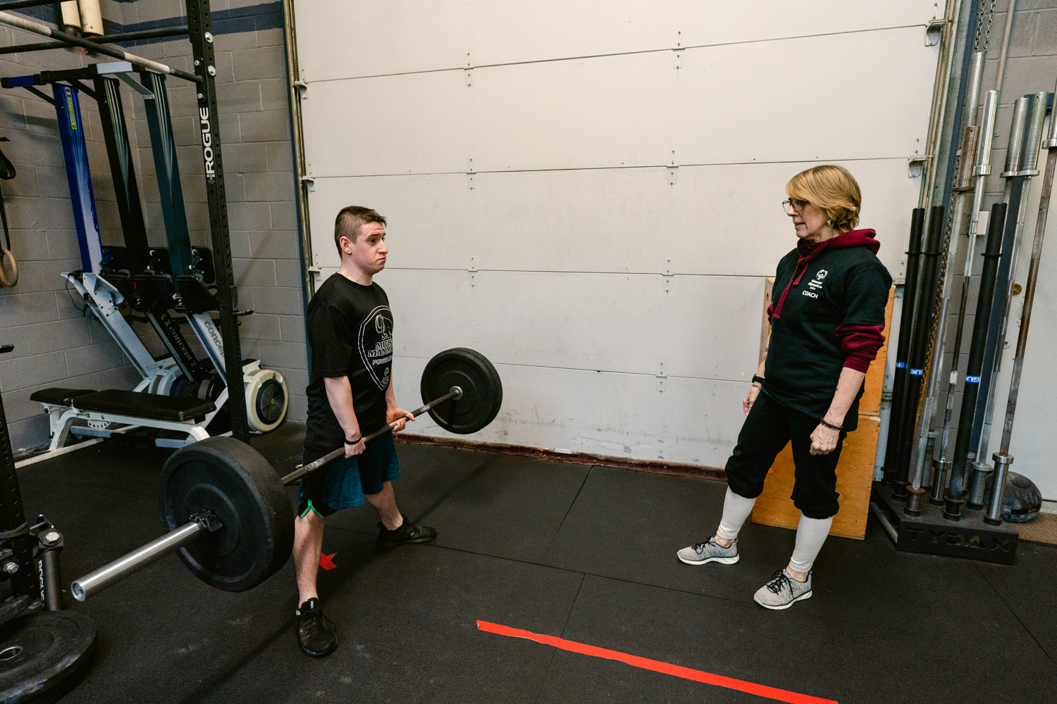Brandle is training in weightlifting under the supervision of his coach.