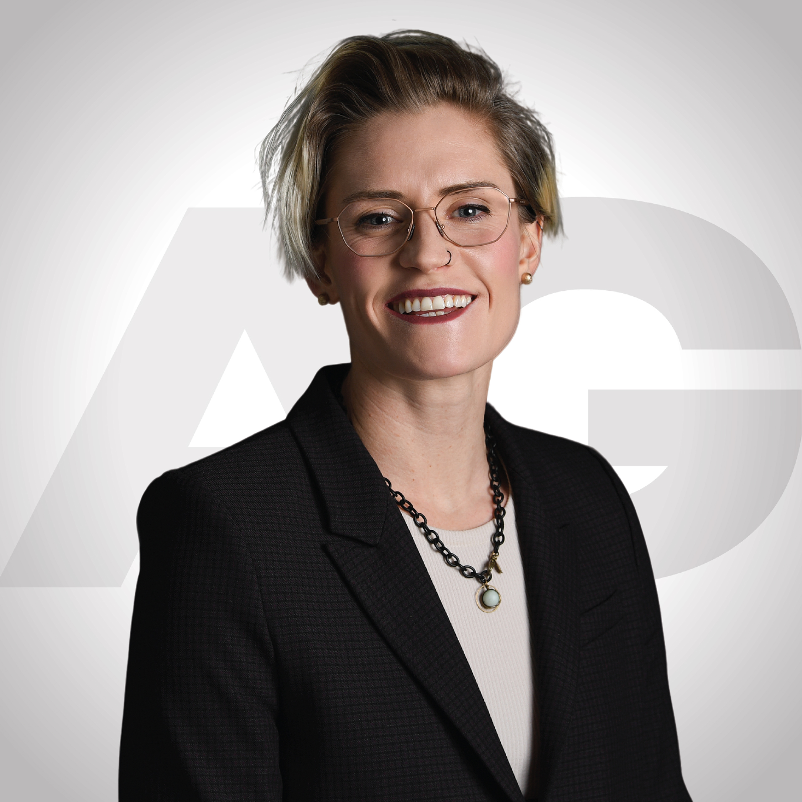 Headshot of a woman with short blond hair and glasses. Headshot of a woman with short blond hair and glasses.