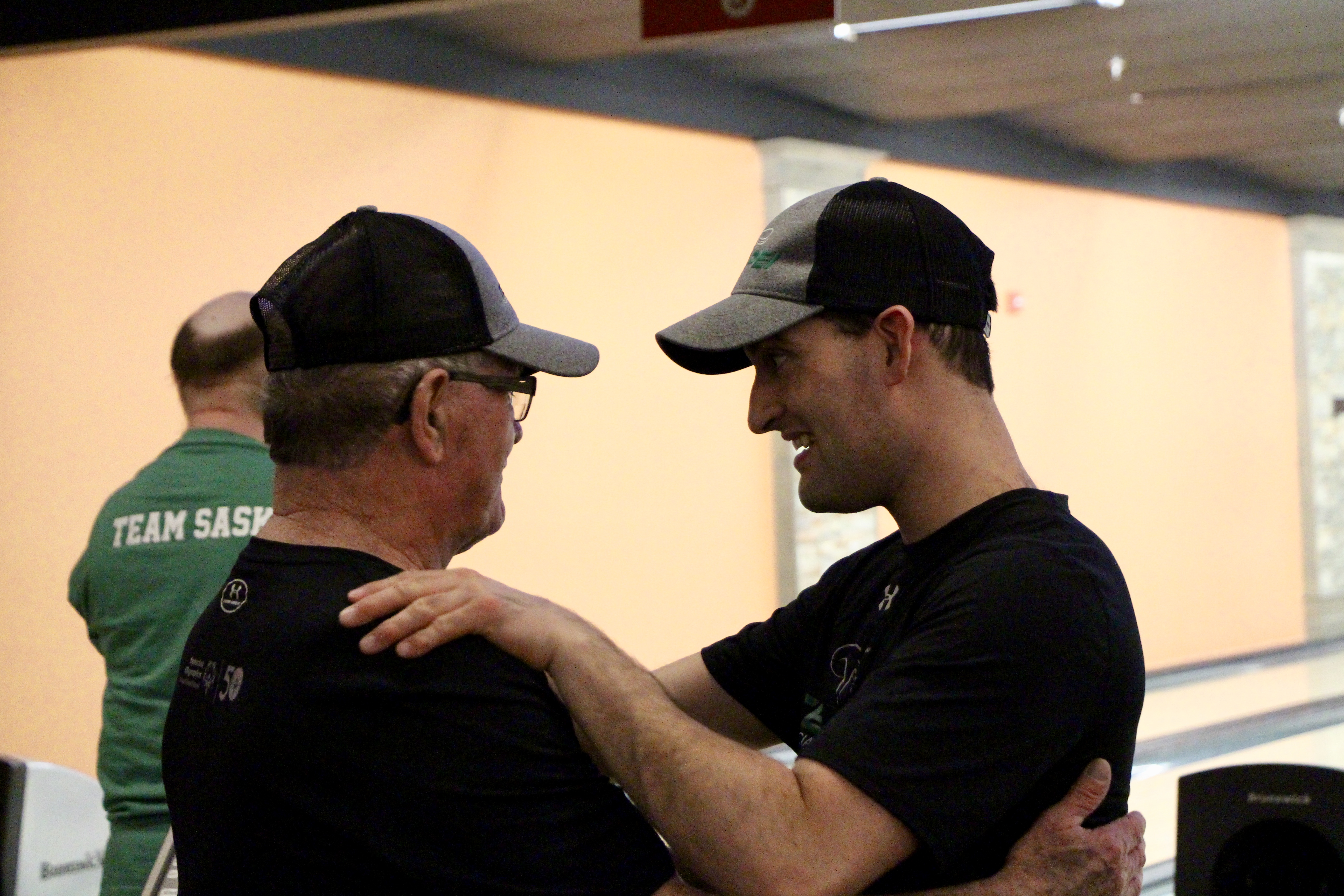 A Special Olympics athlete is supported at bowling by his coach; Rickey Burns