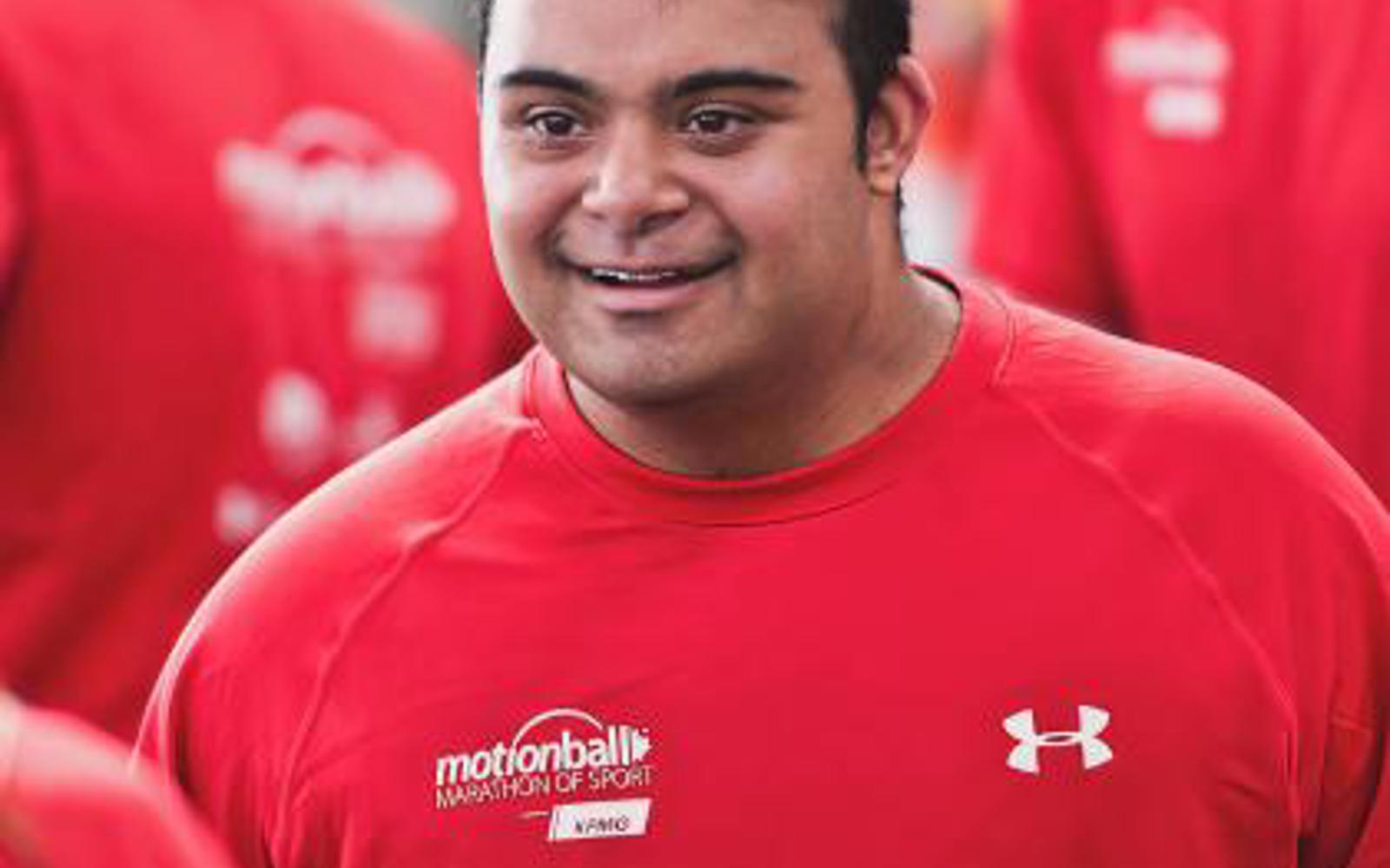 man in a red shirt that says Motionball smiles towards the camera. 