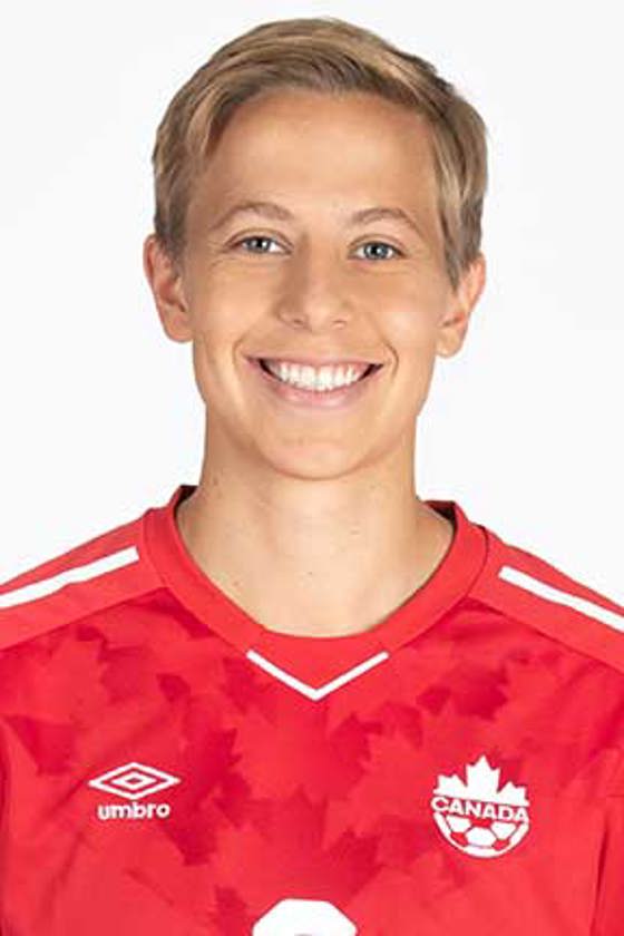 Gros plan sur le visage d'une personne aux cheveux blonds courts portant un maillot de football canadien.