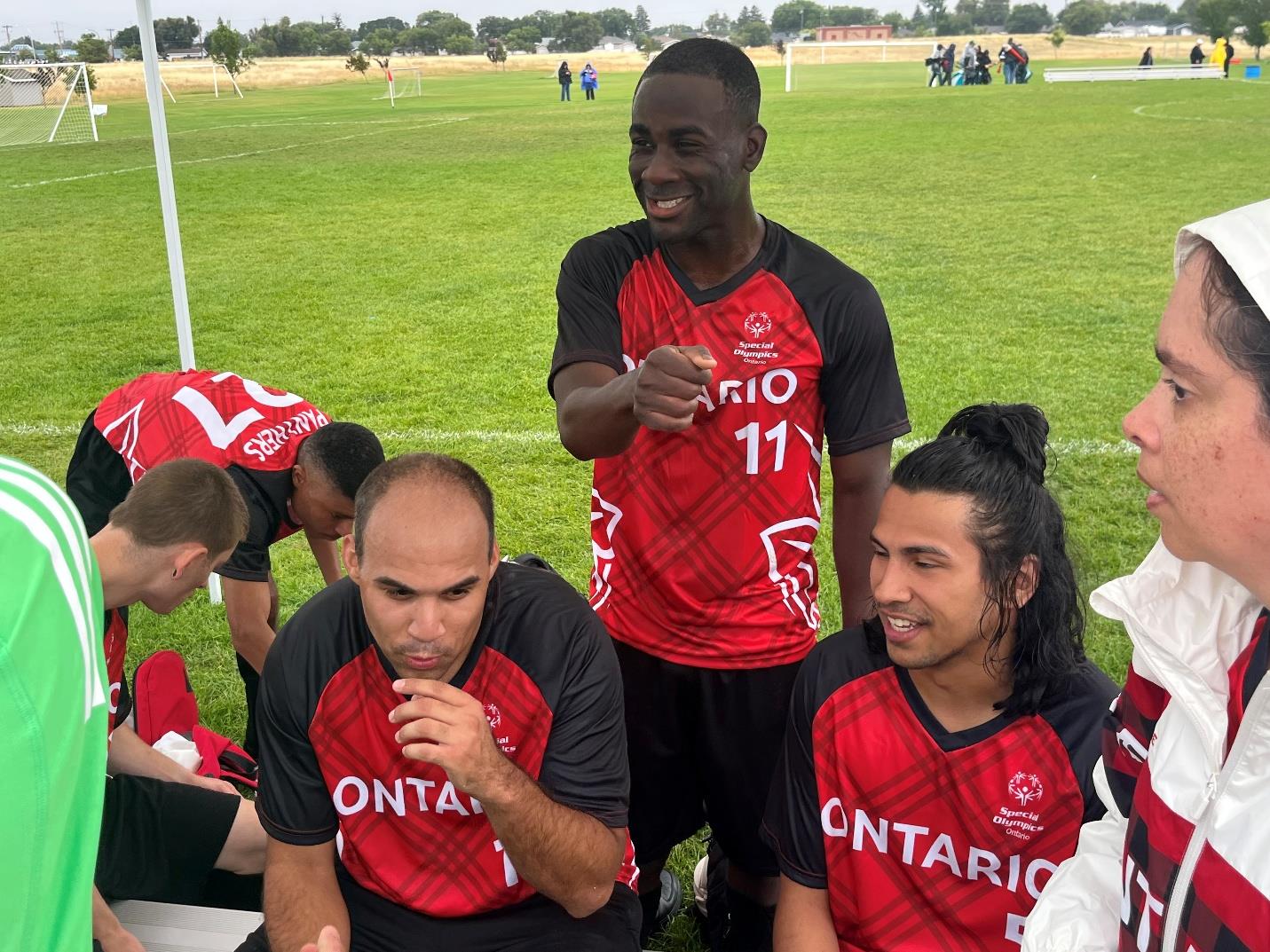Dante (right) stands with teammates Brady (left) and Eddie (centre) near the Team Ontario soccer bench after a win against Special Olympics British Columbia. Dante (right) stands with teammates Brady (left) and Eddie (centre) near the Team Ontario soccer bench after a win against Special Olympics British Columbia.