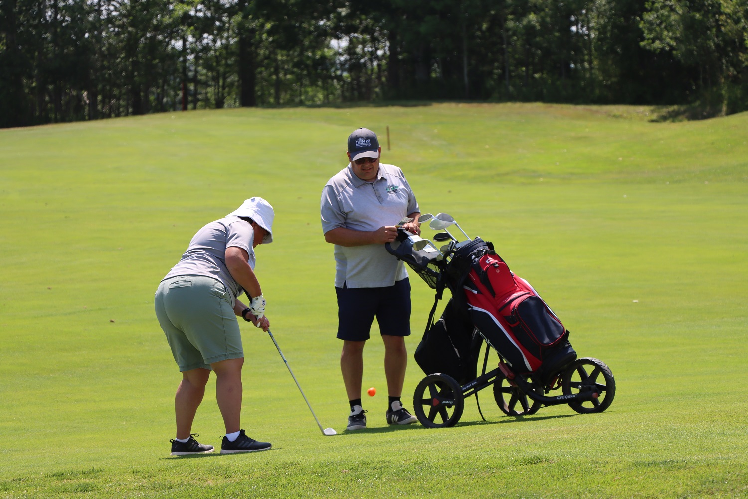 Team PEI 2026 Golf athlete, Heidi Mallett, taking a shot with Coach / Caddie watching
