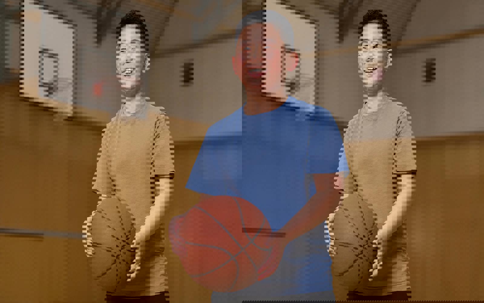 Young boy in blue shirt holding a basketball 