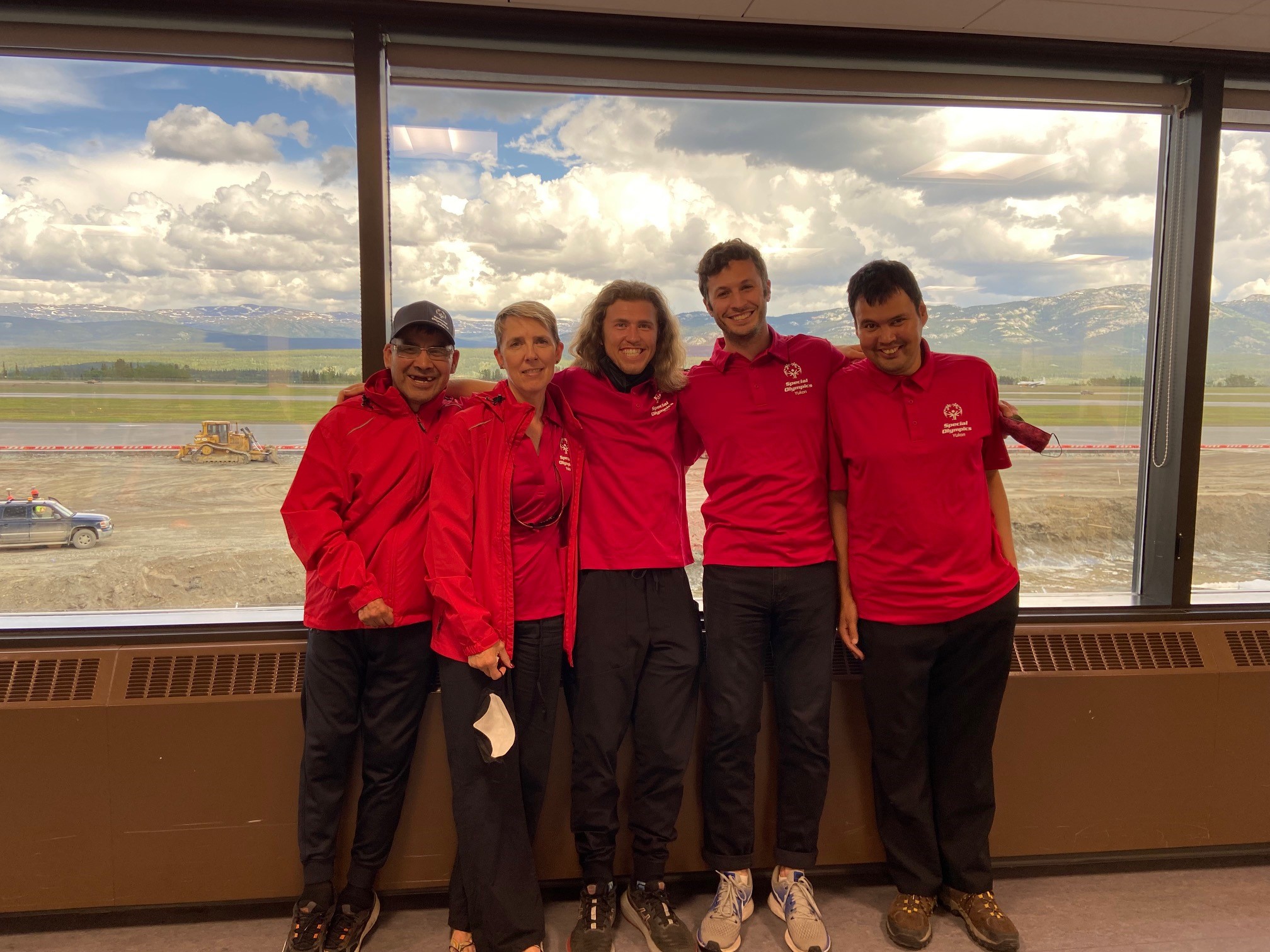 Leah Greenway, Darby McIntyre, and teammates pose together indoors in red jackets. Leah Greenway, Darby McIntyre, and teammates pose together indoors in red jackets.