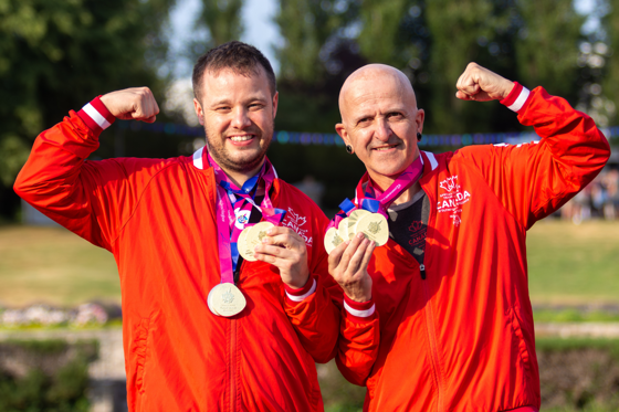 Deux athlètes vêtus de l'uniforme de l'équipe canadienne, une médaille autour du cou.