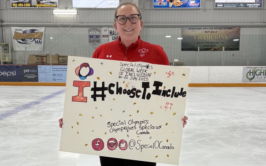 Une fille tenant une pancarte sur une patinoire. La pancarte dit « I #ChosetoInclude » (J'ai choisi d'inclure).