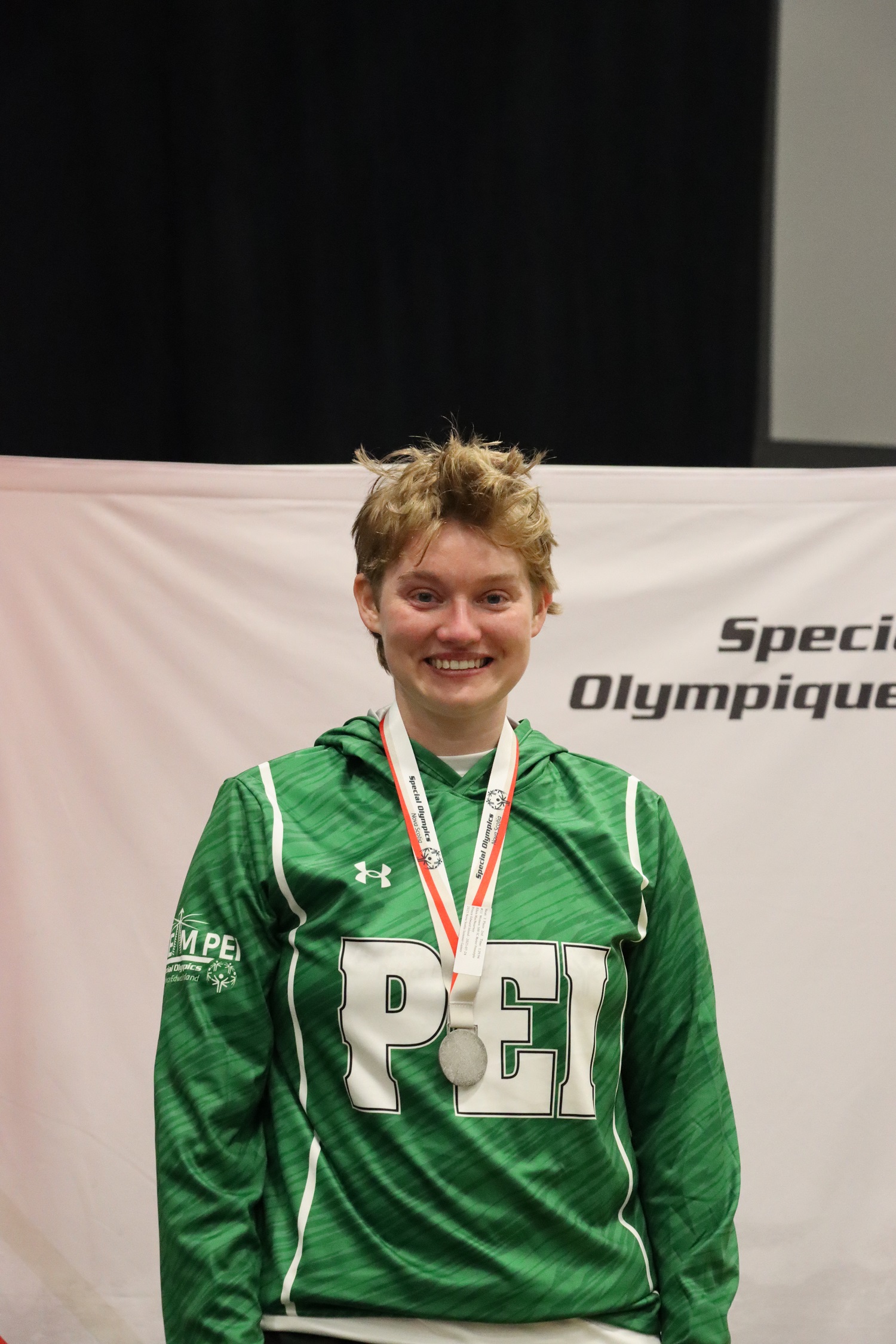 Team PEI 2026 Swimming athlete, Ellen MacNearney, standing on a podium with a medal