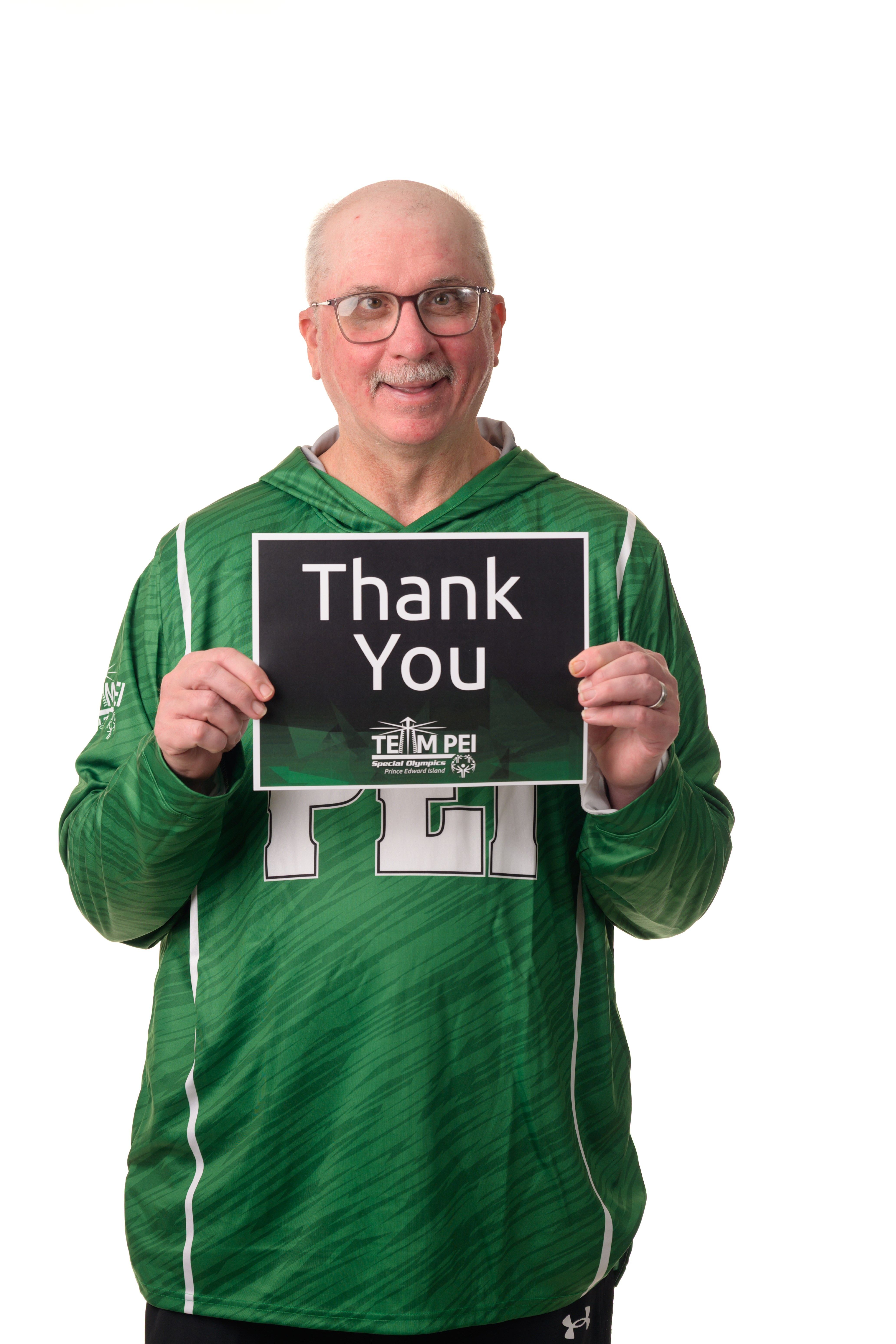 Team PEI 2026 Softball athlete, Tommy MacGuigan, standing with a thank you sign