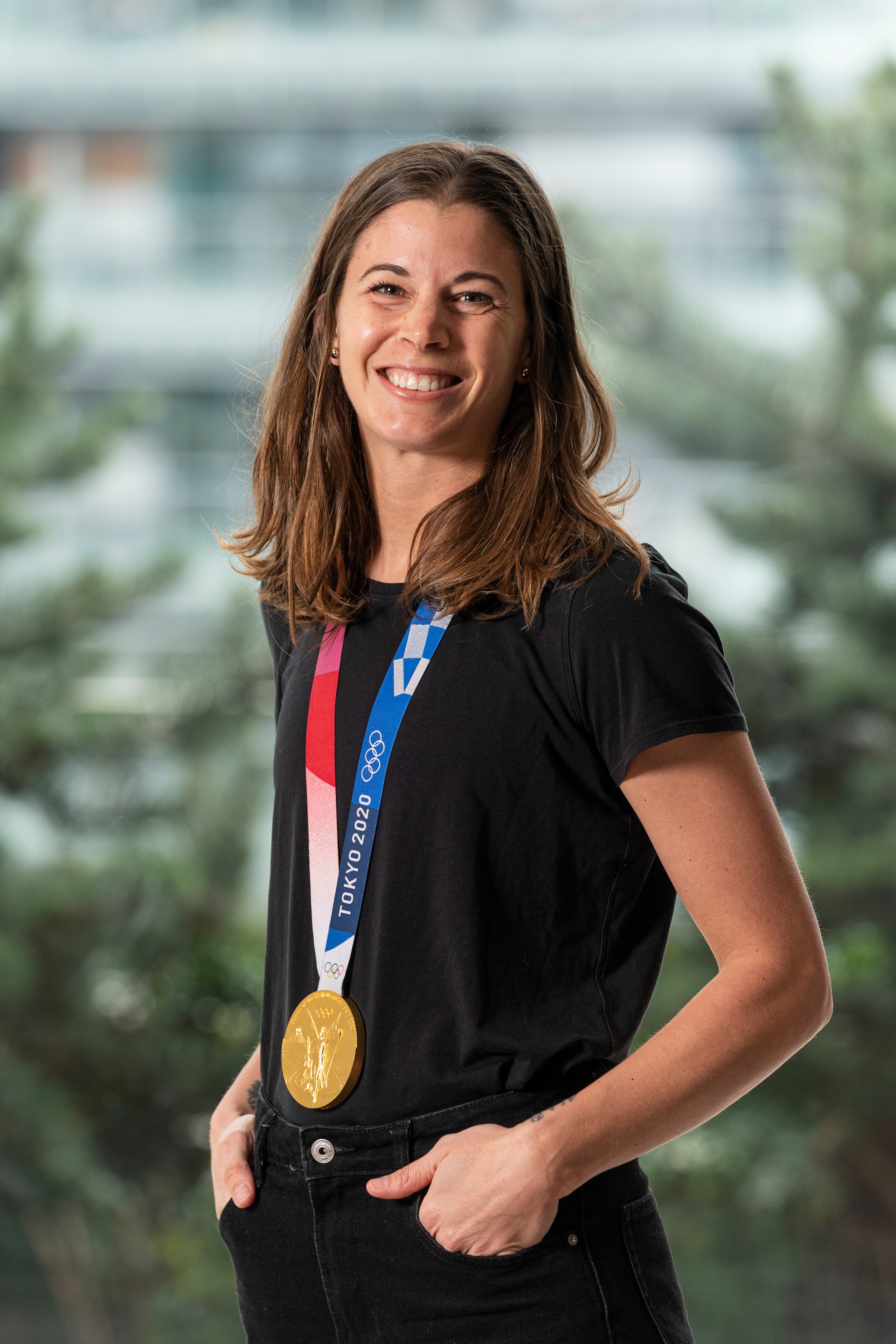 Headshot of a woman with long dark hair wearing a black shirt. Around her neck is an Olympic medal from Tokyo 2020. Headshot of a woman with long dark hair wearing a black shirt. Around her neck is an Olympic medal from Tokyo 2020.