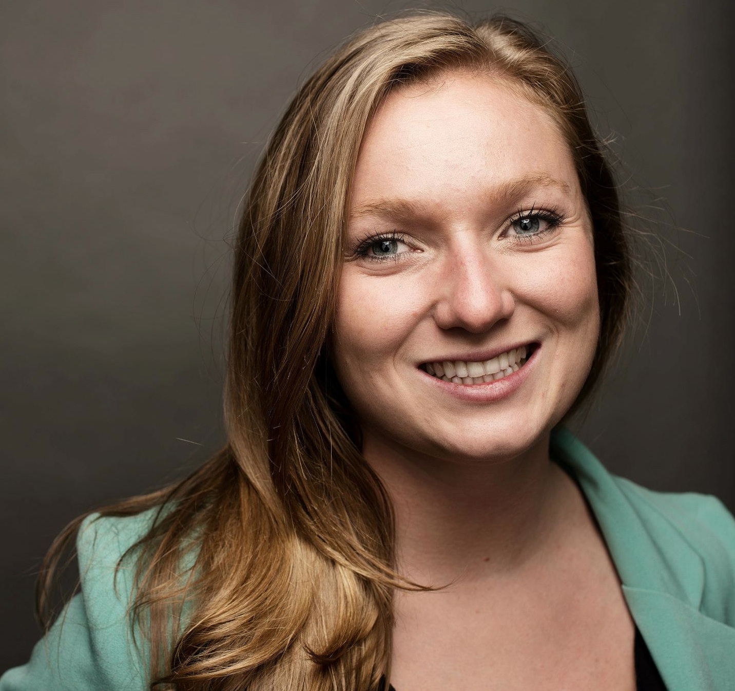 Headshot of a woman with long blond hair in a pale green blazer. Headshot of a woman with long blond hair in a pale green blazer.