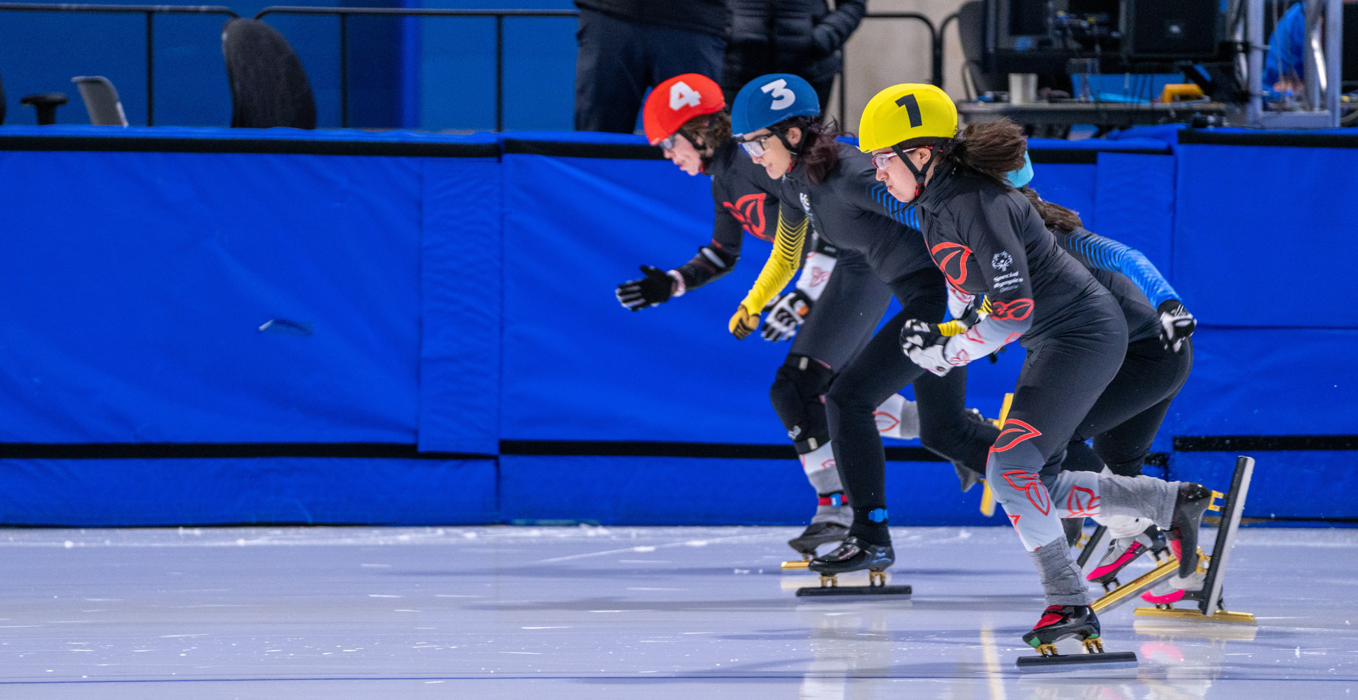 Three speed skaters participate in a race. 