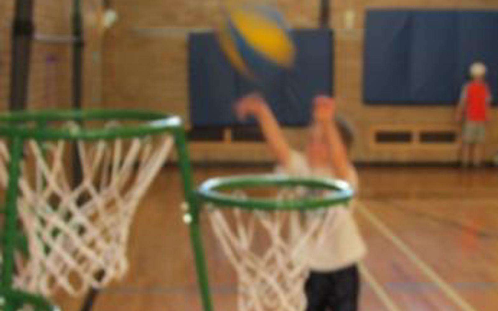 Blurry photo of a small child throwing a basketball into a net