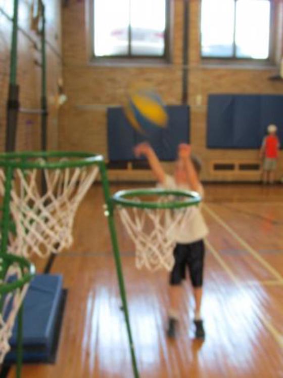 Blurry photo of a small child throwing a basketball into a net