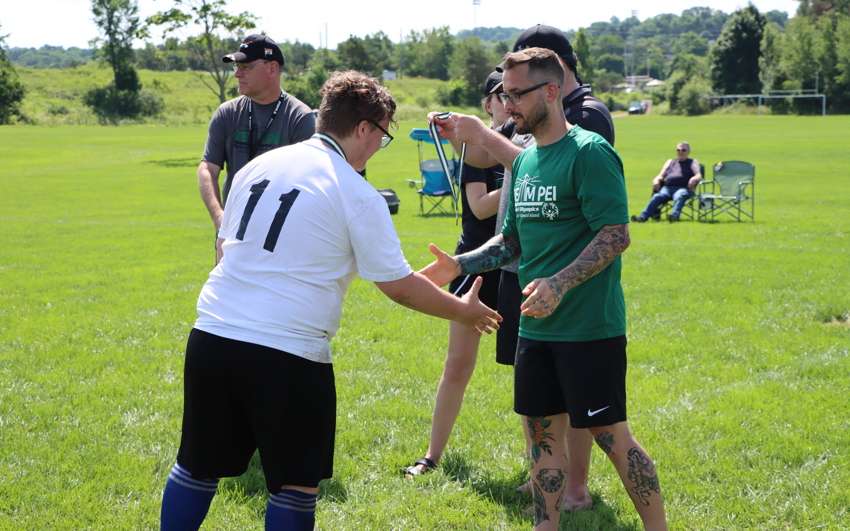 Soccer coach shaking hands with an athlete following a game