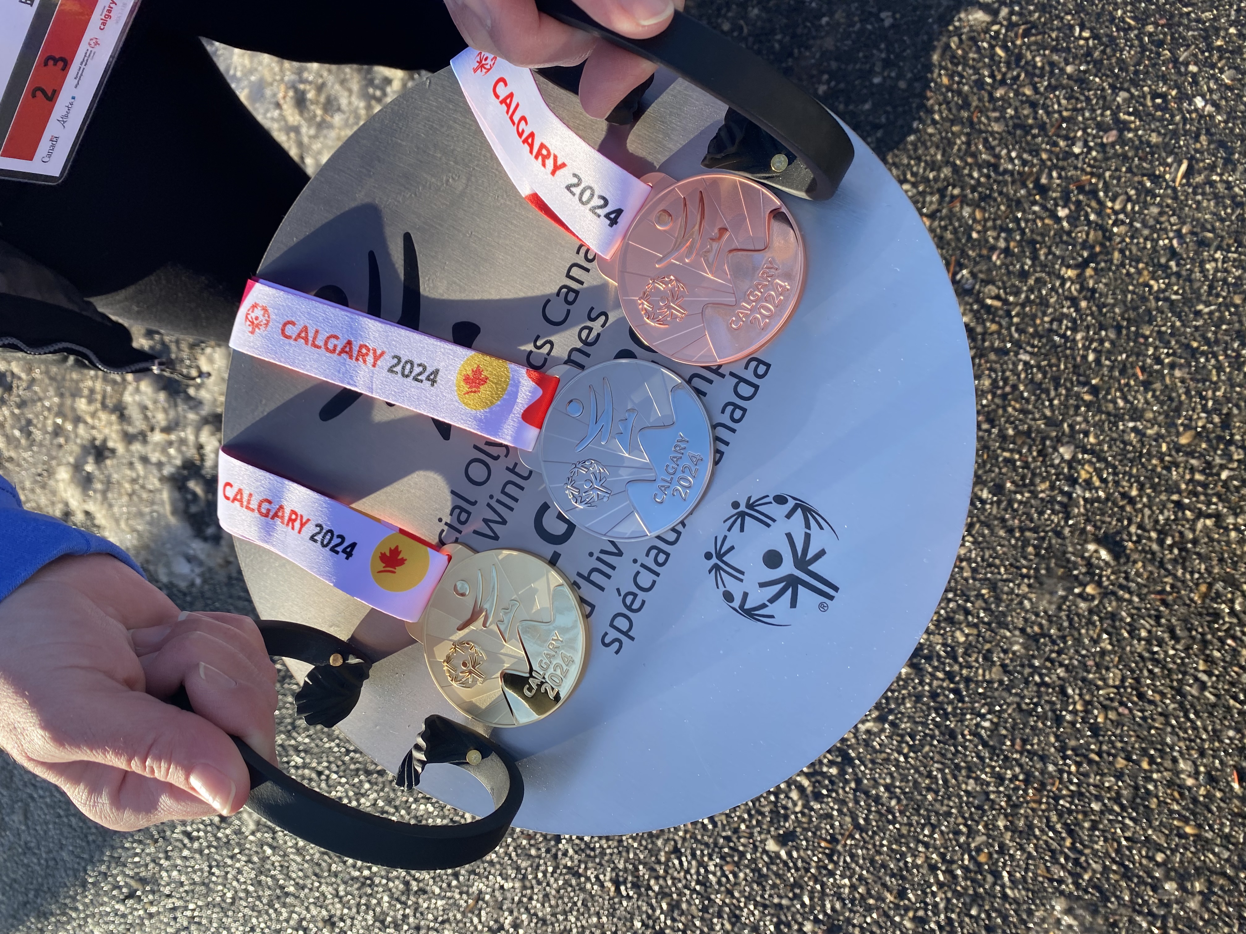 A close up image of gold, silver, and bronze medals. A close up image of gold, silver, and bronze medals.