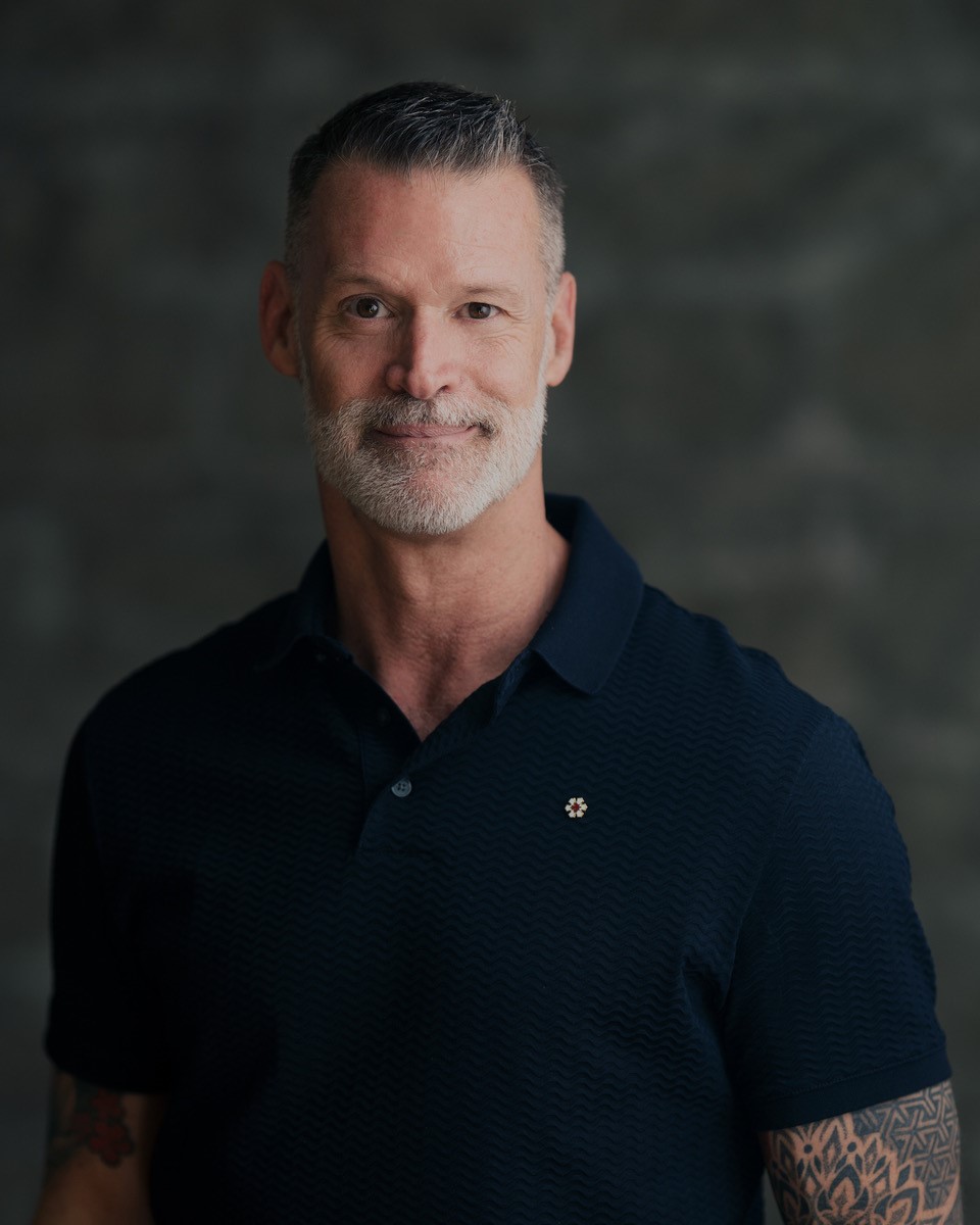 Headshot of a man in a black polo shirt. Headshot of a man in a black polo shirt.