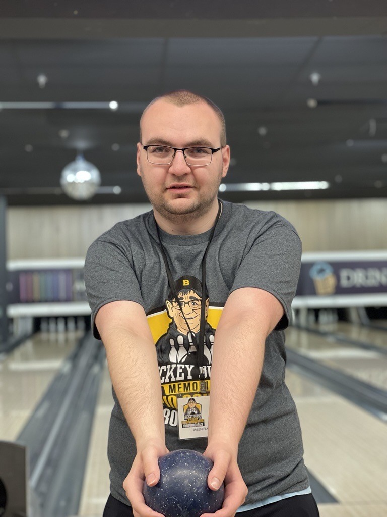A Special Olympics athletes at the bowling lanes, holding a bowling ball