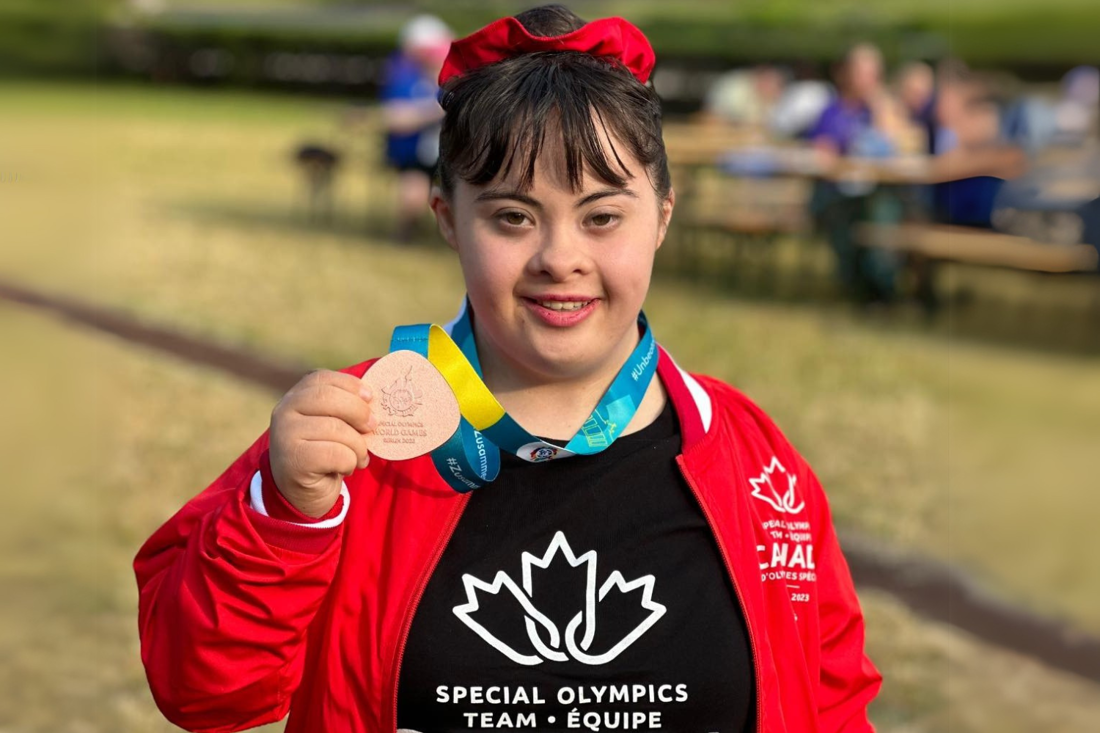 One athlete in Team Canada uniforms with medals around their necks. 