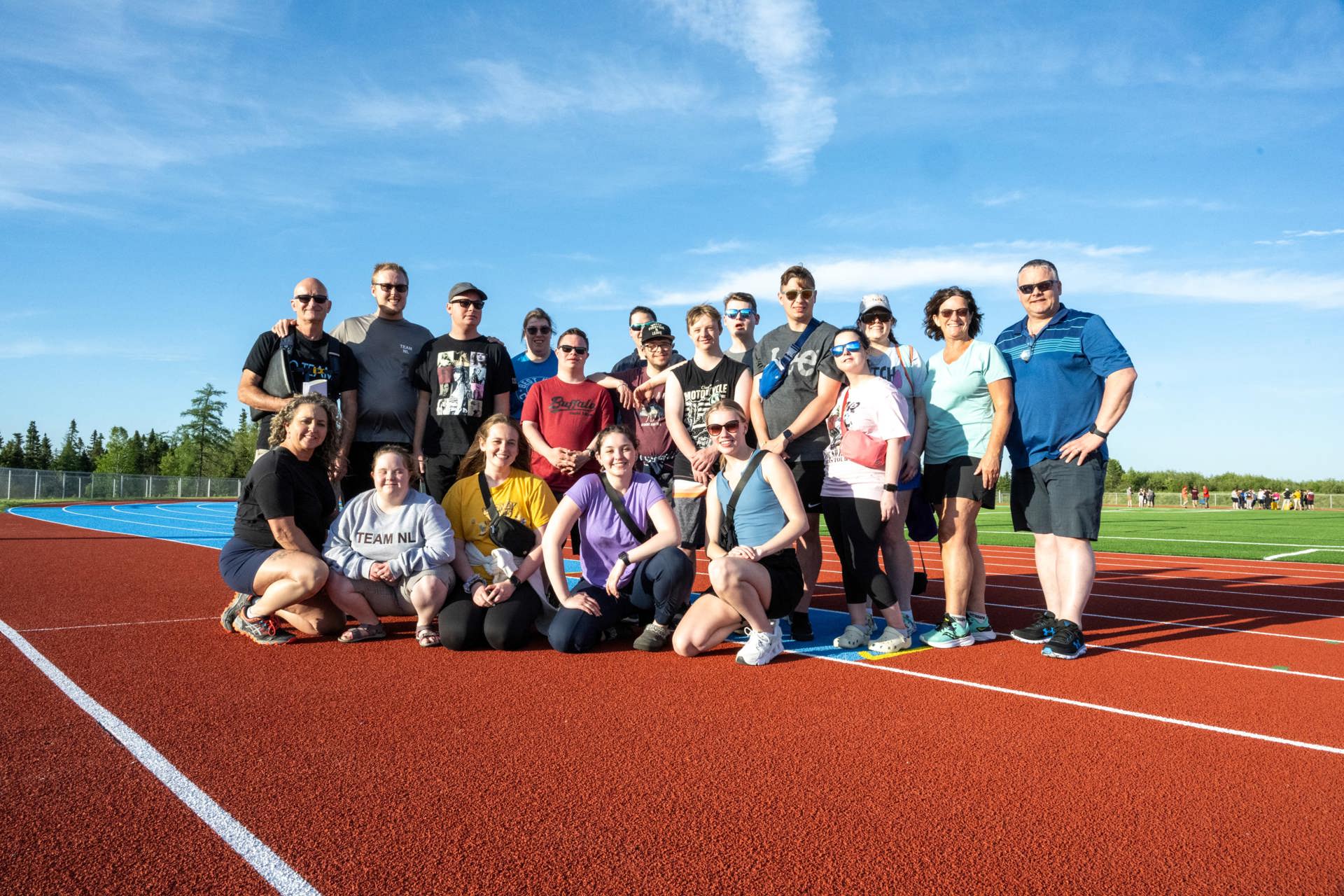 A group photo on the track. There are 19 people in the photo.