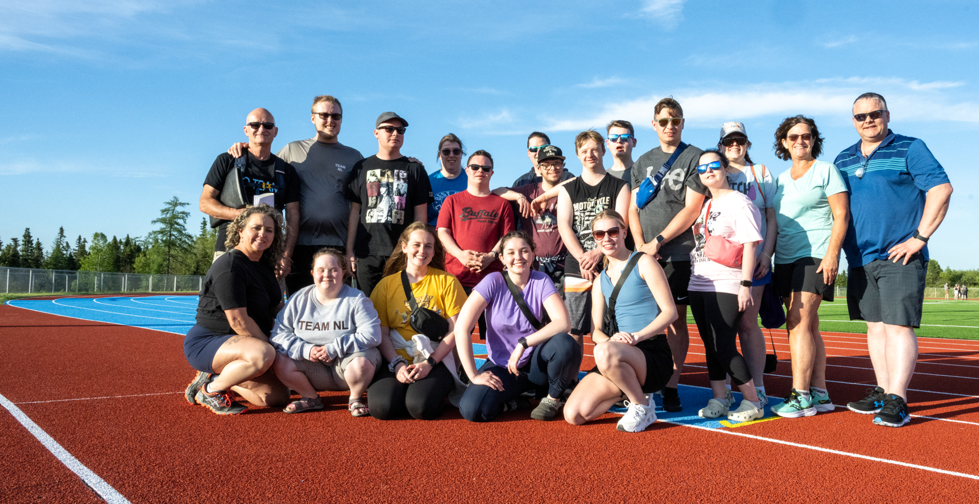 A group photo on the track. There are 19 people in the photo.
