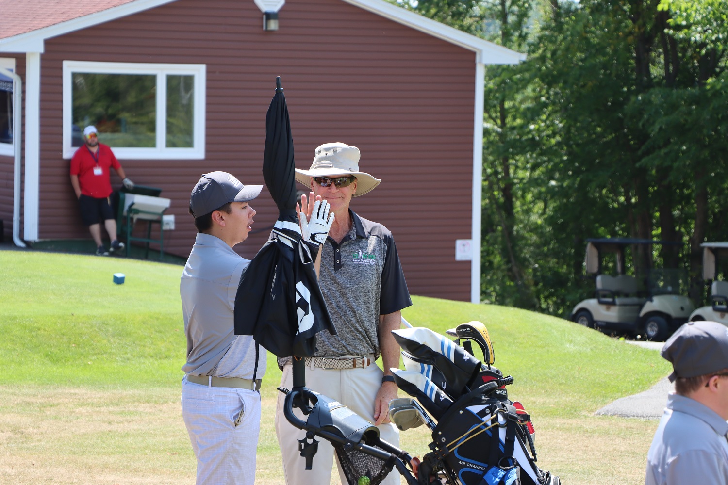 Team PEI 2026 Golf athlete, Matthew Jehn, giving his Coach / Caddie a high five