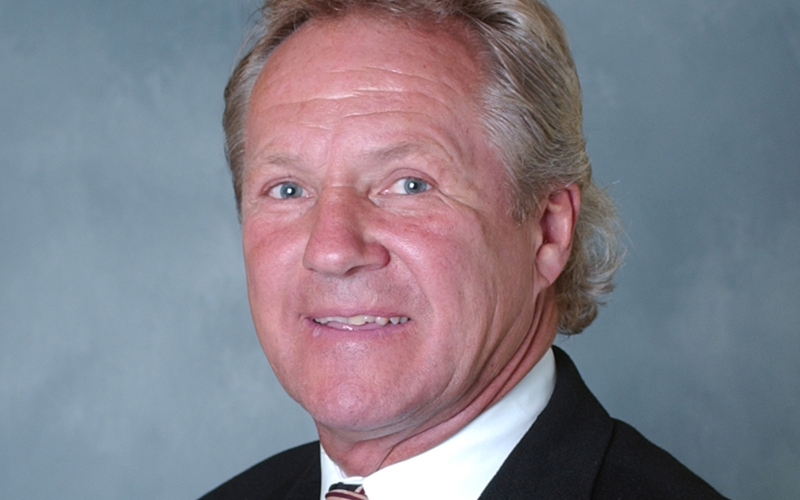 Gros plan sur le visage d'un homme portant un pull-over zippé orné du drapeau canadien.