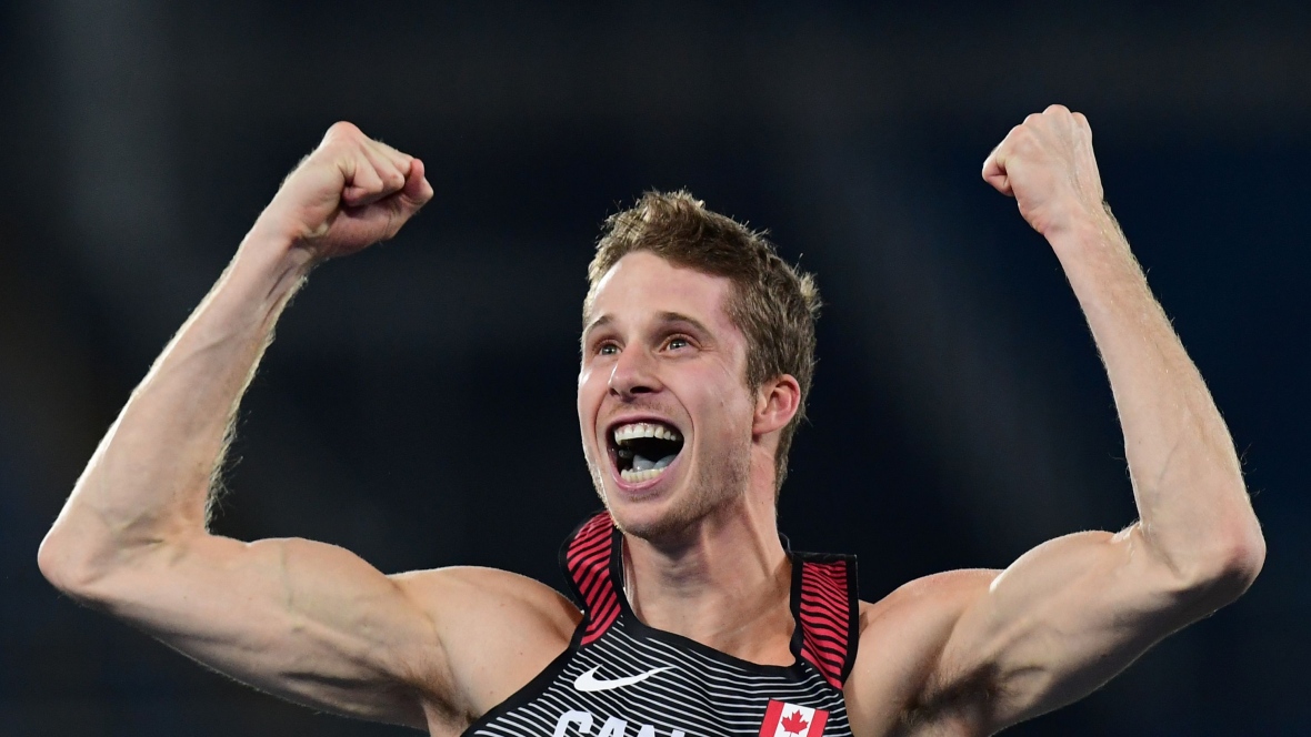 Man in an athletic tank with arms in the air cheering. Man in an athletic tank with arms in the air cheering.