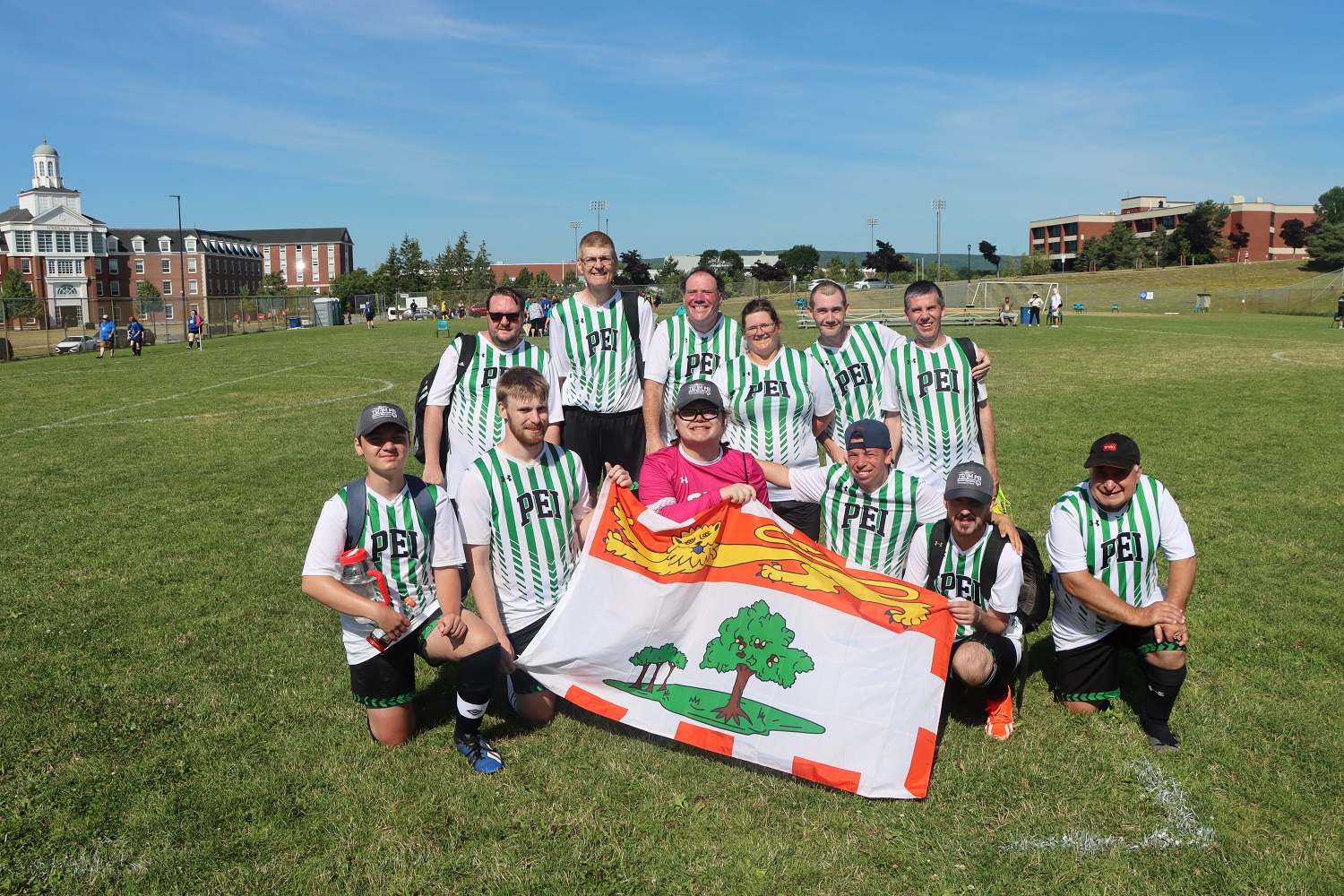 Team PEI 2026 Soccer standing together and holding the PEI flag