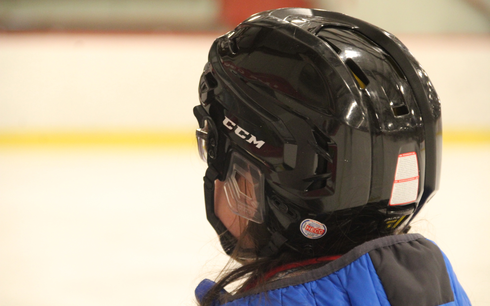 Close up shot of a person wearing a black hockey helmet