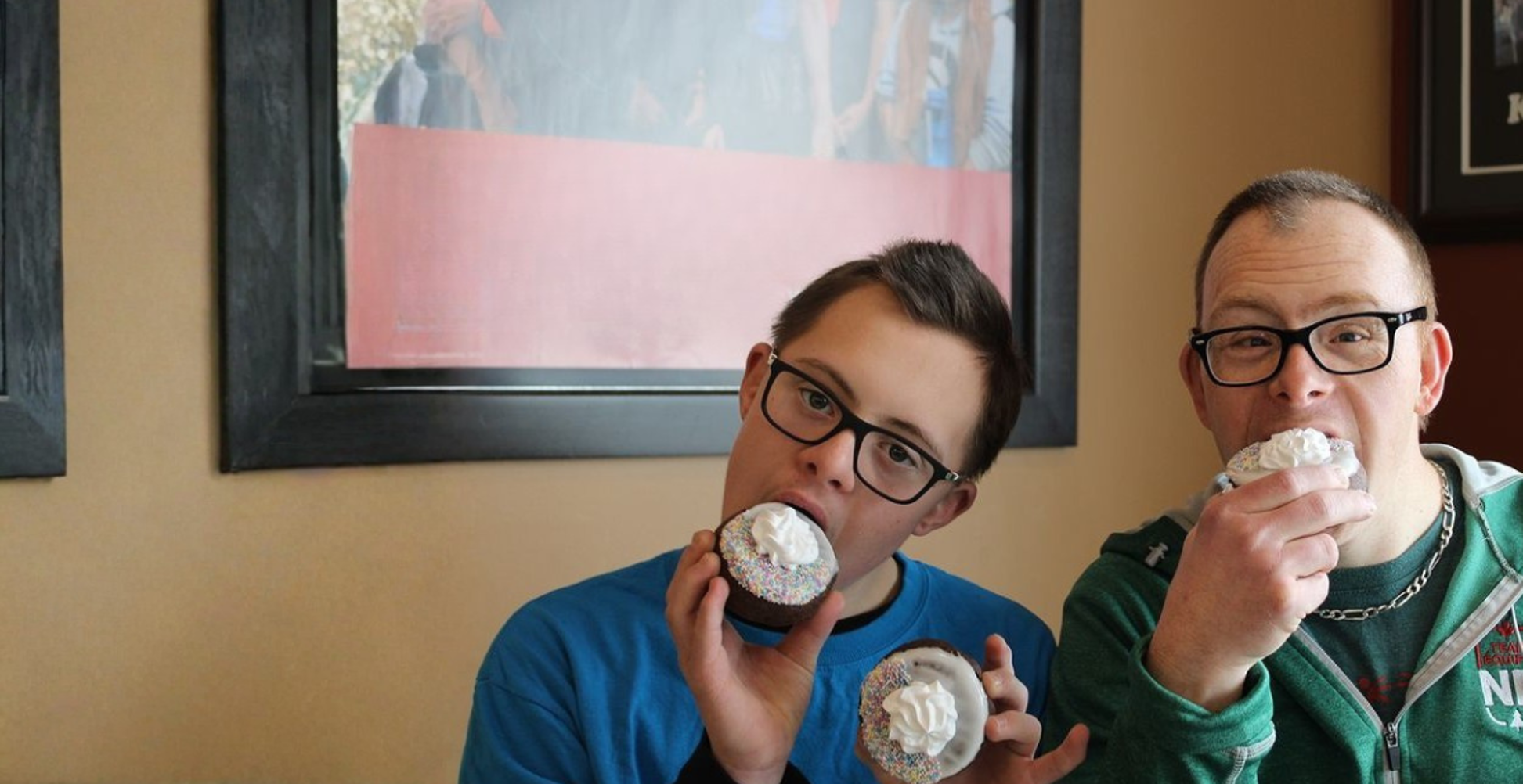 deux hommes mangeant des beignets