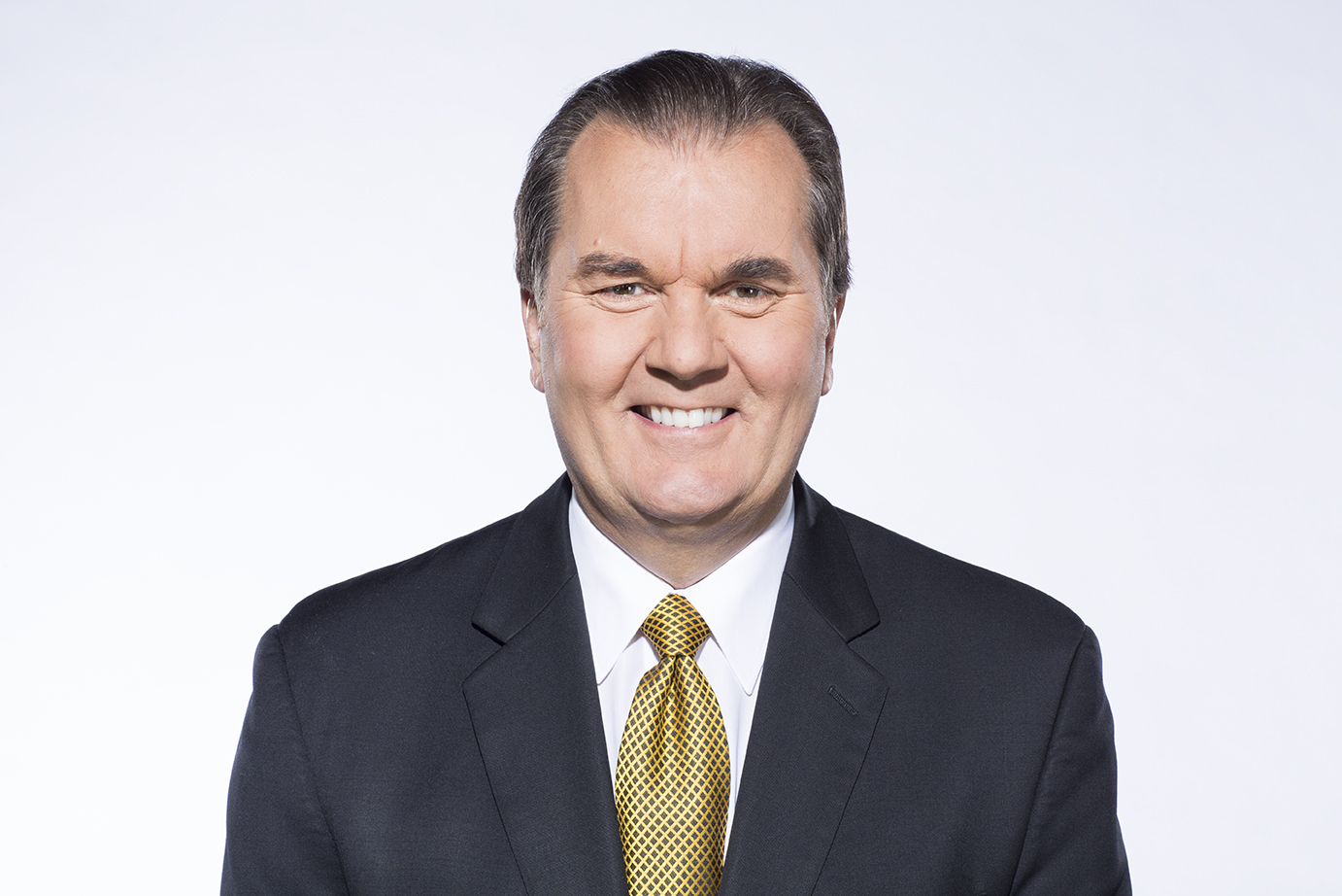 Headshot of a man in a black blazer, white shirt and yellow and black tie. Headshot of a man in a black blazer, white shirt and yellow and black tie.