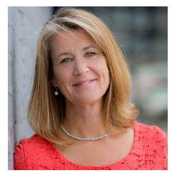 Women with long blond hair and bright orange sweater with pearls. 