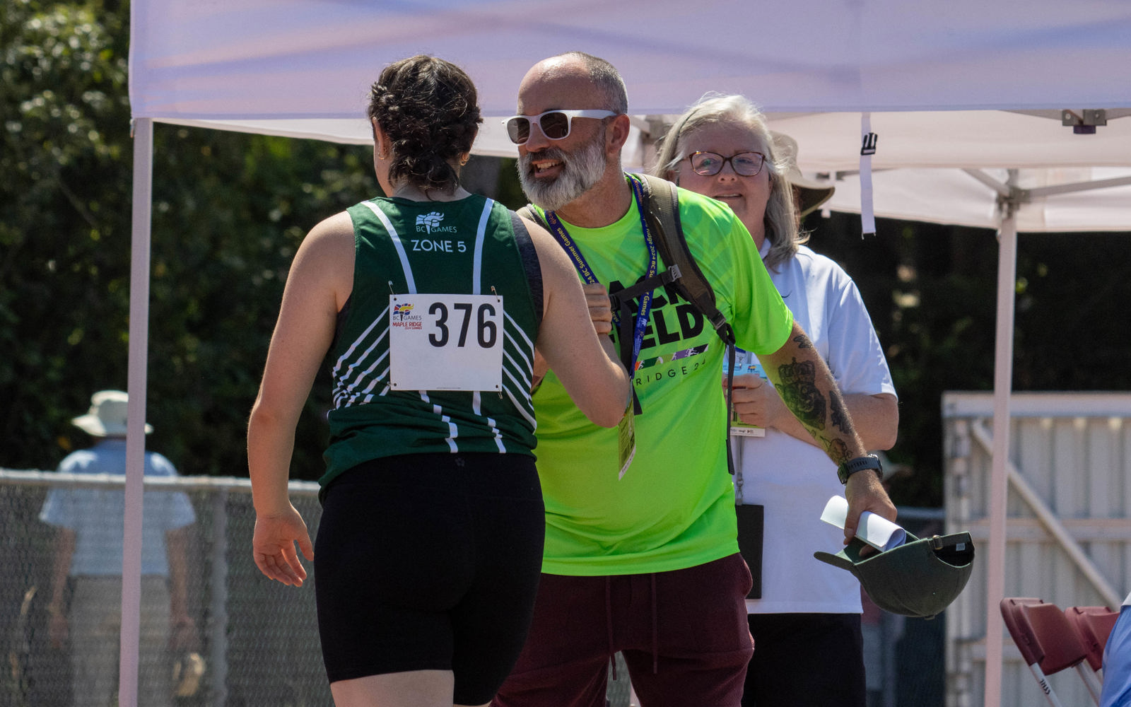 An athletics athlete high fives her coach at a competition.