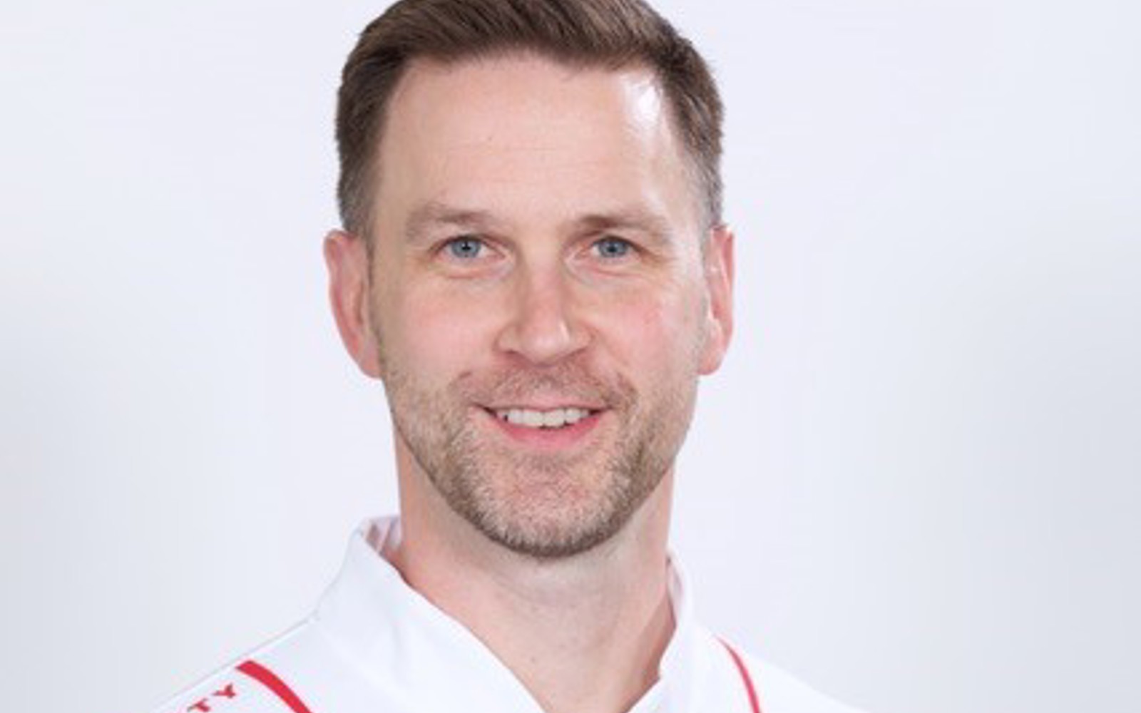 Gros plan sur le visage d'un homme portant un maillot avec le logo Tim Hortons.