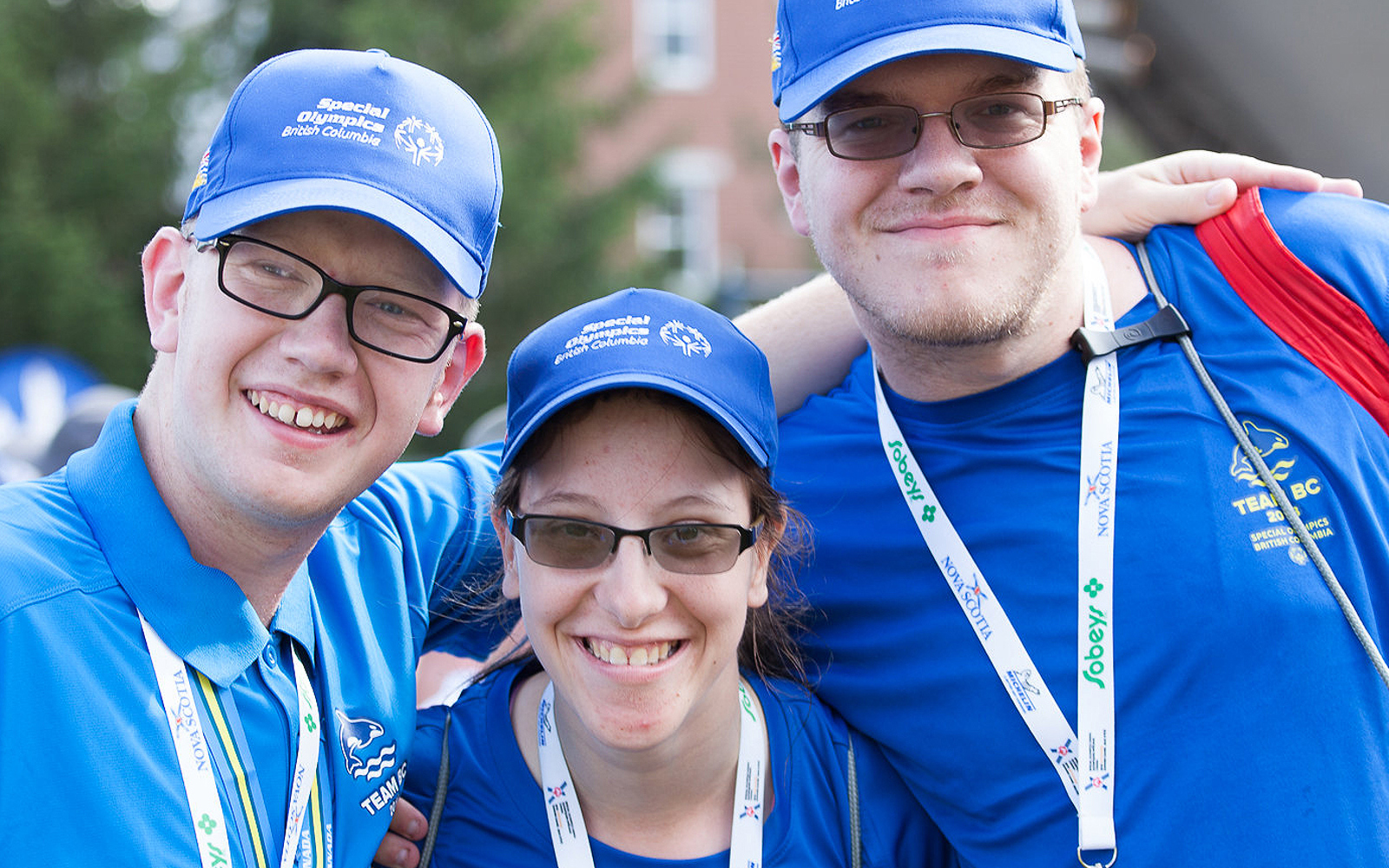 Three Special Olympics BC athletes pose for the camera wearing their Team BC apparel.