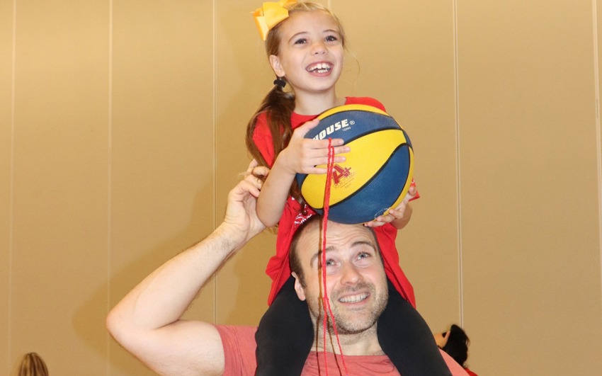 Sophia on guardians shoulders playing basketball.